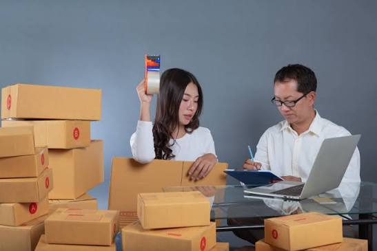 Pemilik toko retail sedang memeriksa selisih stok barang di rak toko