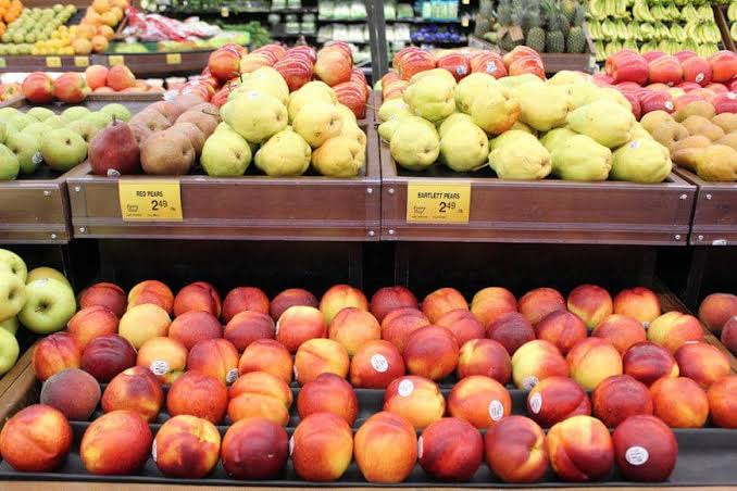 Pemilik toko buah menata produk segar untuk meningkatkan penjualan di toko