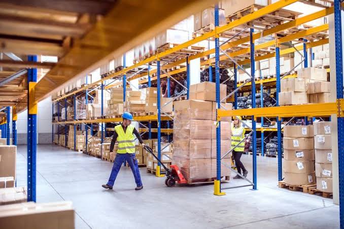 Pemilik toko memeriksa selisih antara stok fisik dan catatan barang di gudang